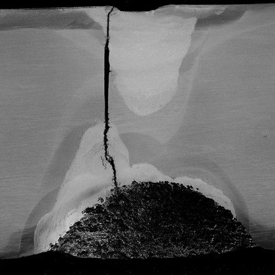Macrography of the longitudinal section of the valve body, at the cracked position close to the actuator hole.  The valve body is 40 mm thick and at this position it is possible to see that there are two regions where the body was welded, close to the inner surface (bottom) and at the close to the outer surface (top). The through wall crack presented a branch aspect close to the repair in the ID and a straight aspect when propagating from the repair.