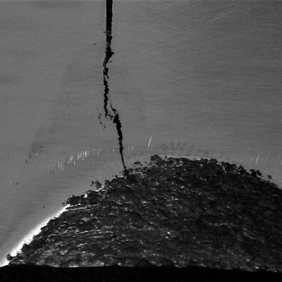 Macrographic detail of the cracked position close to the actuator hole.  The through wall crack presented a branch aspect in the weld metal, that is the original defect created during welding, and a straight aspect when propagating from the repair.