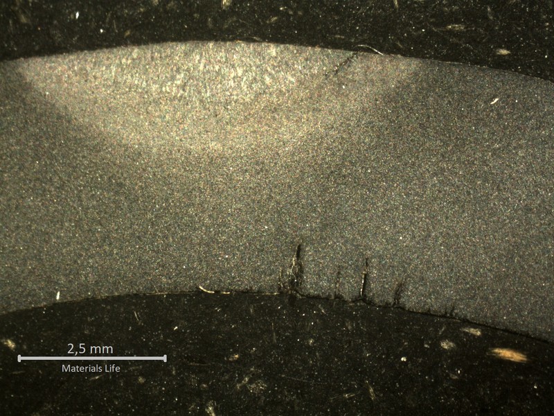 Macrography of the transverse section of the tube, in a position where the cracking was not yet through wall. The internal tube surface shows multiple corrosion fatigue cracks, parallel, under the weld of the membrane, probably related to the cold side of the tube (the cracks opened to the boiler outside).   The external side of the tube presenting a small crack at the margem of the weld, suggesting also the action of thermal stresses.