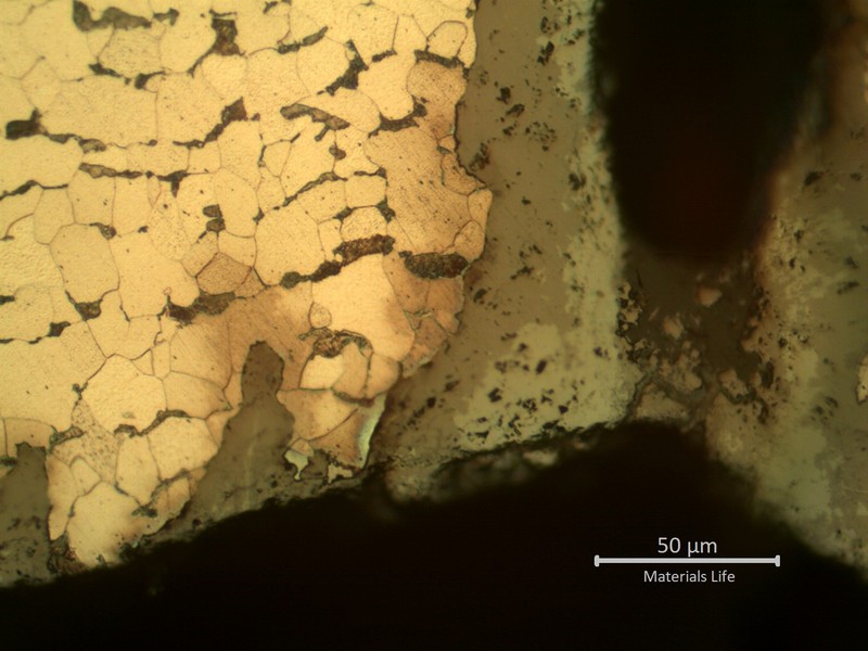Micrographic detail of the parallel cracks growthing from pits.