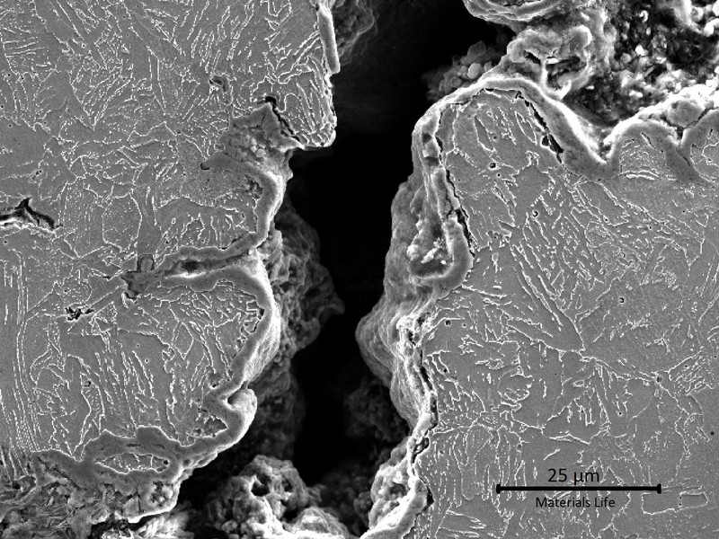 Micrographic detail, by scanning electron microscopy, of the external tube surface, presenting the crack at the weld margin.  The microstructure if ferritic in the left side (weld metal) and bainitic in the right side of the crack (heat affected zone).