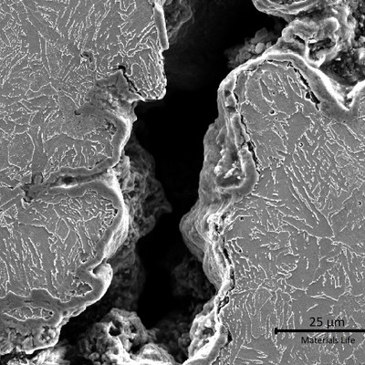 Micrographic detail, by scanning electron microscopy, of the external tube surface, presenting the crack at the weld margin.  The microstructure if ferritic in the left side (weld metal) and bainitic in the right side of the crack (heat affected zone).