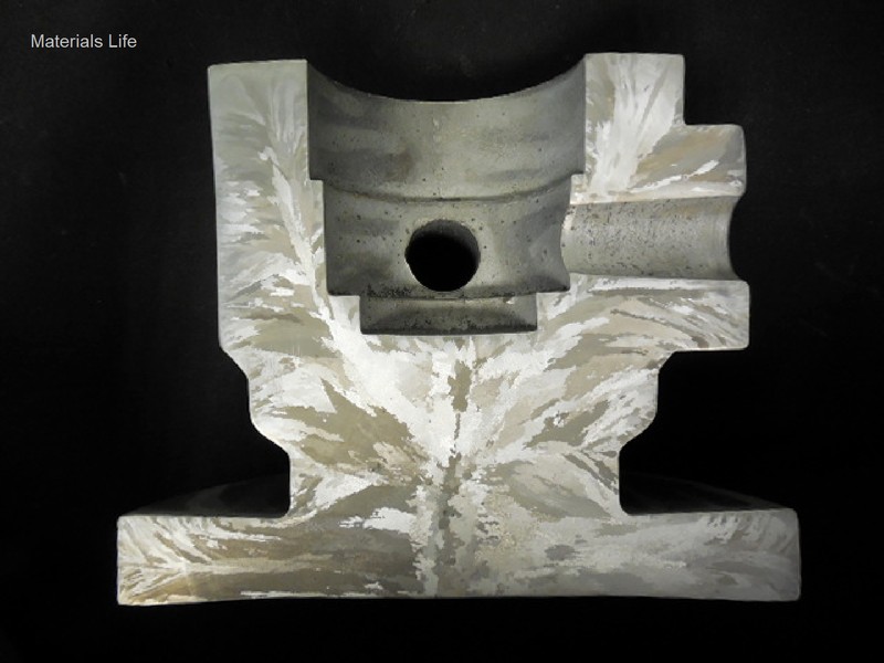 Macrography of a longitudinal section of the valve body, presenting the granular structure. The main bore diameter is 2". The casting was tested in two positions.  In radial direction in the center of the body (3" solid), and in the longitudinal direction in the wall (1" thick).
