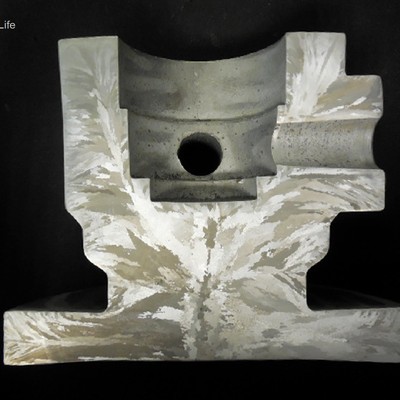 Macrography of a longitudinal section of the valve body, presenting the granular structure. The main bore diameter is 2". The casting was tested in two positions.  In radial direction in the center of the body (3" solid), and in the longitudinal direction in the wall (1" thick).