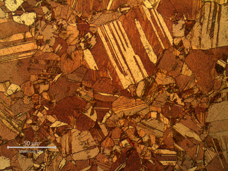 Micrographic detail of the alpha microstructure presenting dual grain sizes. Two different types of twins are presented in the structure: annealing twins and deformation twins, suggesting that the material was probably partially recristalized after cold deformation and stress relief treatment.