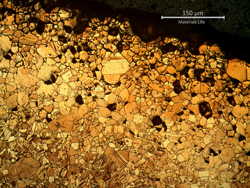 Micrography of the external side of the bent tube, showing detachement of several grains due to intergranular corrosion. The corroded layer is about 200 microns thick at this position. The differences of colours in the corroded layer suggests a dealloying effect, also known as selective leaching.