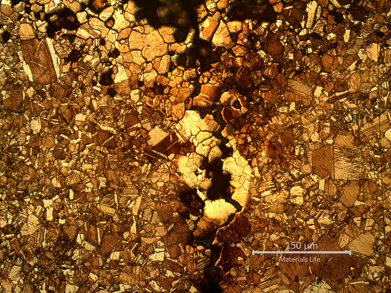 Micrography close to the external surface (to the top). The layer of intergranular corrosion shows evidences of selective leaching (suggesting that the aluminum was preferentially consumed). The stress corrosion cracking starts from the intergranularly corroded layer.