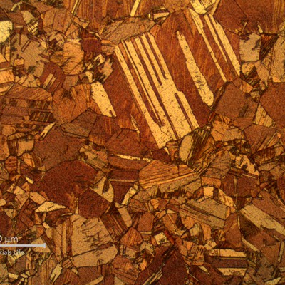 Micrographic detail of the alpha microstructure presenting dual grain sizes. Two different types of twins are presented in the structure: annealing twins and deformation twins, suggesting that the material was probably partially recristalized after cold deformation and stress relief treatment.
