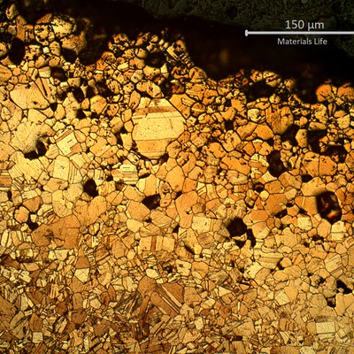 Micrography of the external side of the bent tube, showing detachement of several grains due to intergranular corrosion. The corroded layer is about 200 microns thick at this position. The differences of colours in the corroded layer suggests a dealloying effect, also known as selective leaching.