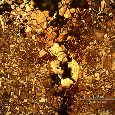 Micrography close to the external surface (to the top). The layer of intergranular corrosion shows evidences of selective leaching (suggesting that the aluminum was preferentially consumed). The stress corrosion cracking starts from the intergranularly corroded layer.