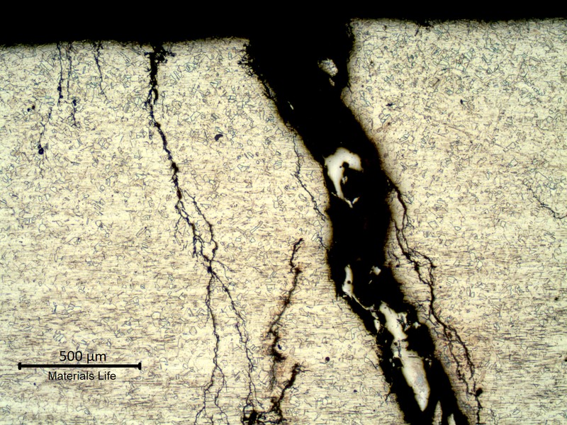 Micrography of the stub end close to the external surface, outer diameter in the top of the image, presenting multiple cracks starting fro the surface and propagating into the thickness, through wall.