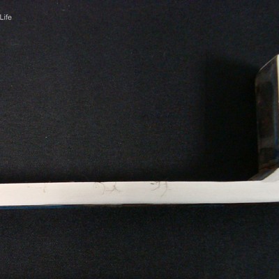 Macrography of the longitudinal section of the stub end, showing the external side to the top and the internal side to the bottom. The stub end was manufactured by welding, longitudinal seam (not evidenced in this image) and circunferential weld of tube to disc (partial penetration). The cracks starts from the external side of the stub end.