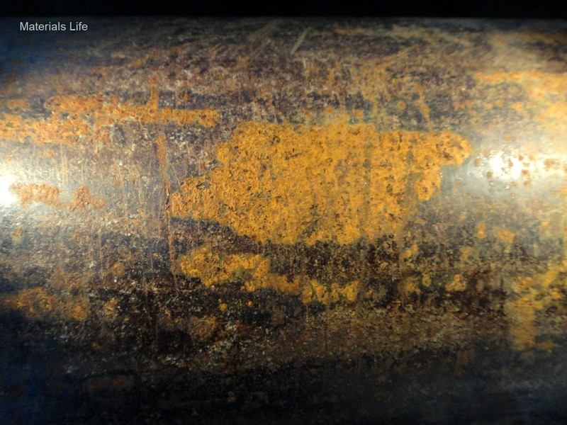 Pipe body surface, adjacent to the fracture, showing regions of corrosion and visual cracks transverse to the pipe axis.