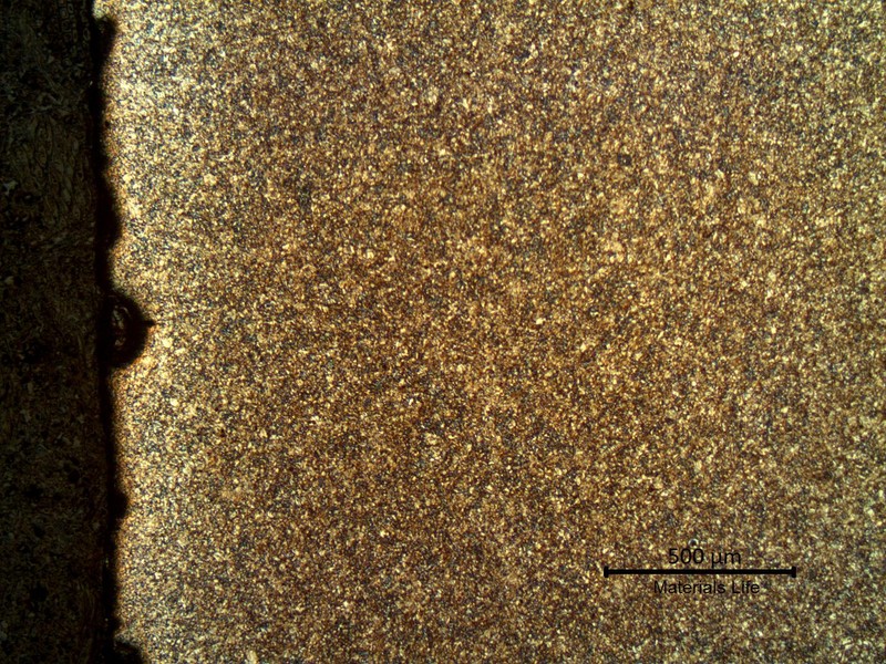 Micrography of a longitudinal section of the pipe, at the external pipe surface, where there is a corroded spot.  The microstructure is tempered martensite and at the surface the pipe is slightly decarburized.