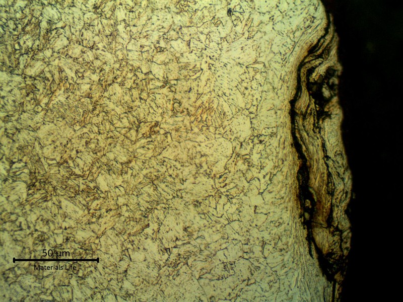 Micrographic detail of the strain hardening effect, probably generated by blasting  before applying the coating. The microstructure is tempered martensite and the surface it is slightly decarburized.