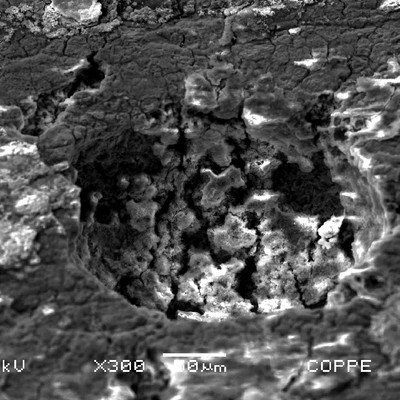 Microscopic detail, by scanning electron microscope,  of a region where there is a localized dissolution at the internal surface of the tube. The deposits are adhered at the surface and under the deposits, the analysis indicated increased sulfur levels, suggesting SRB (sulfate reduced bacteria) effects.