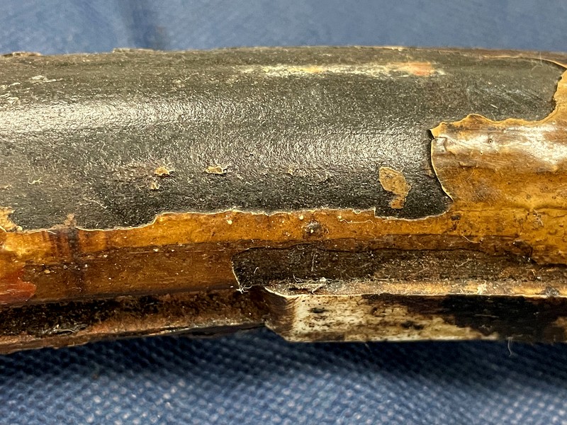 Aspect of the U bolt clamp with partial detachment of the coating (white brown) in a region where the polimeric insert (dirty white) is still in the wire groove at the internal clamp diameter (ID).