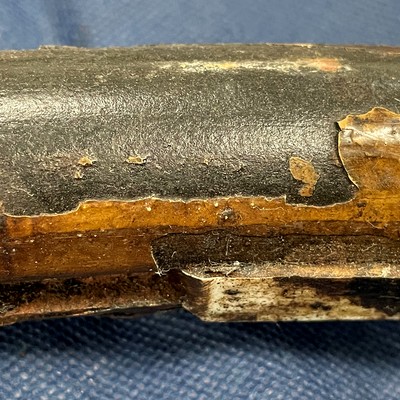Aspect of the U bolt clamp with partial detachment of the coating (white brown) in a region where the polimeric insert (dirty white) is still in the wire groove at the internal clamp diameter (ID).