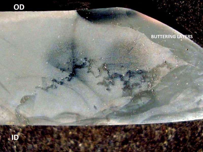 This macrography shows a longitudinal section of the tubular cast fitting.  The external side is to the top and the internal side to the bottom.  The buttering layer is evident in the groove that would be welded to the centrifugall cast tube (right side) and part of the ID and OD.  During the buttering welding of the casting the cracks were not detected because they were formed  in the center of the thickness and some have propagated to the internal diameter, but not to the external diameter. They opened only when the buttered casting was welded to the tube.