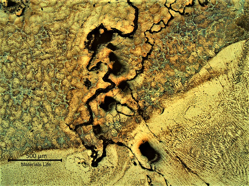 Same region as the previous figure, showing the structure of the base metal and weld metal, at the cracked area.  In the base metal, the cracks are associated to the primary carbides network and in the weld metal it is associated to the solidification columnar grains.
