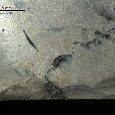 Macrographic detail close to the internal diameter (ID in the bottom), where the cracks were detected by dye check (after removal of the damaged part of the cast fitting). Close to the surface it is possible to see the layers of the weld metal that corresponds to the cast fitting buttering.