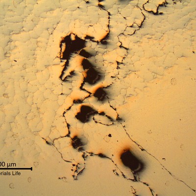 As polished micrography of the fusion line presenting several microcracks . The base metal is to the top and the weld metal is to the bottom.