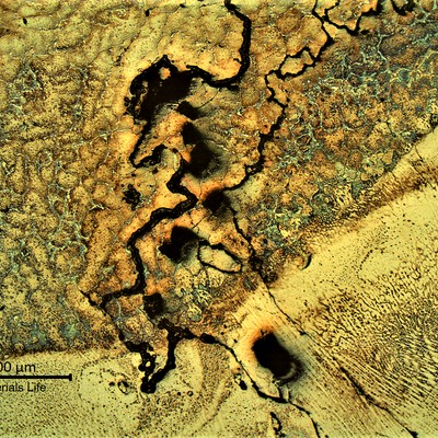 Same region as the previous figure, showing the structure of the base metal and weld metal, at the cracked area.  In the base metal, the cracks are associated to the primary carbides network and in the weld metal it is associated to the solidification columnar grains.