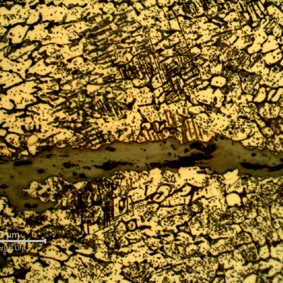 Detailed microstructure of the weld metal, exposed to high temperature exhausting gases.  Austeno-ferritic structure, strong carbide precipitation integranular and transgranular, and some cracks.