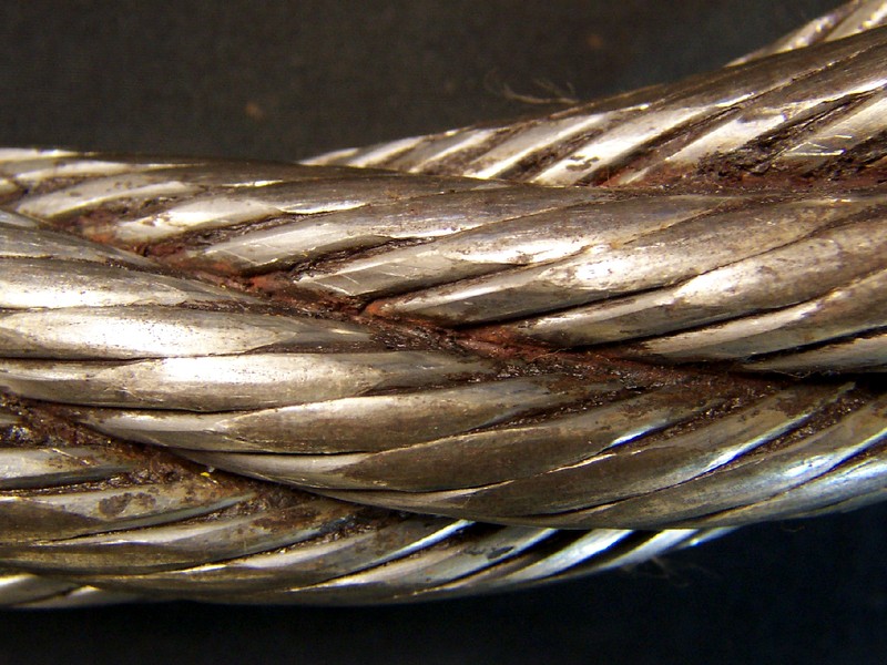 Aspect of the wire rope, 1 1/2" diameter, presenting regions of flattened areas at the surface of the outer wires. It is a 6 x 19 Seale construction, right regular lay.