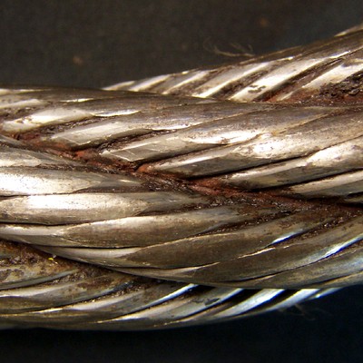Aspect of the wire rope, 1 1/2" diameter, presenting regions of flattened areas at the surface of the outer wires. It is a 6 x 19 Seale construction, right regular lay.