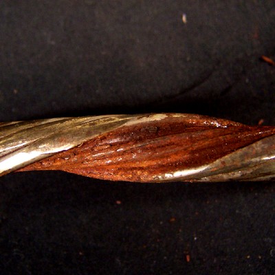 One disassembled strand without the core of the strand, showing an internal rusted surface, and externally flattened areas (left side of the figure).