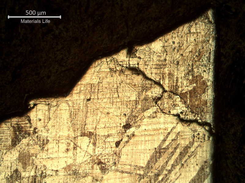 The main crack is to the top and the blade surface is to the right, in this micrography that does not reveal any plastic deformation, with transgranular and integranular cracks.