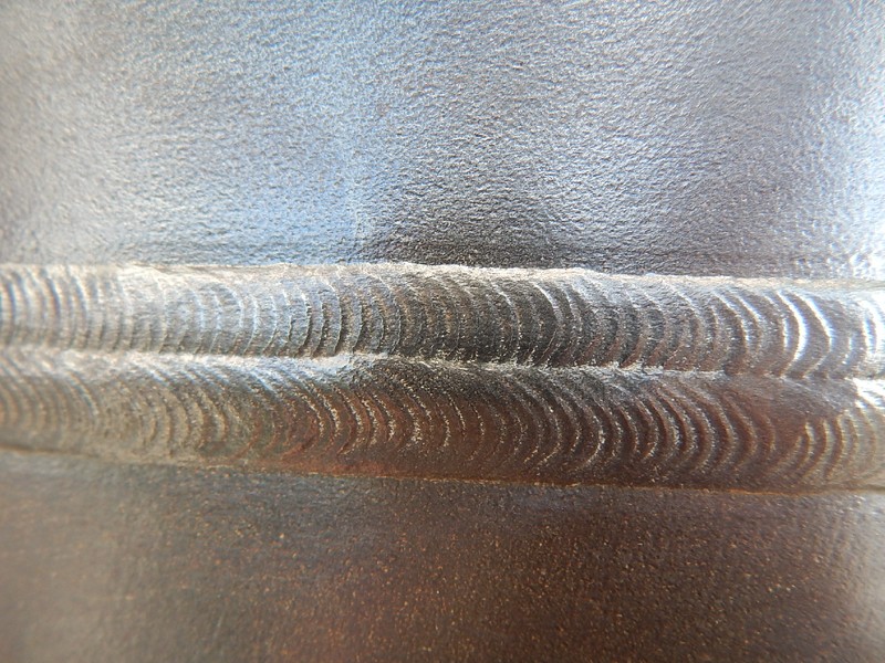 Circumferential weld aspect. Two passes in the cap. This forging to pipe welded joint, 22 mm thick, was welded by an automatic process in a narrow gap.  The pipe is to the top of the image and the forging is to the bottom of the image.