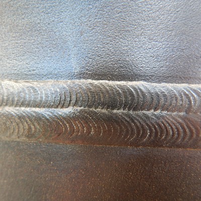 Circumferential weld aspect. Two passes in the cap. This forging to pipe welded joint, 22 mm thick, was welded by an automatic process in a narrow gap.  The pipe is to the top of the image and the forging is to the bottom of the image.