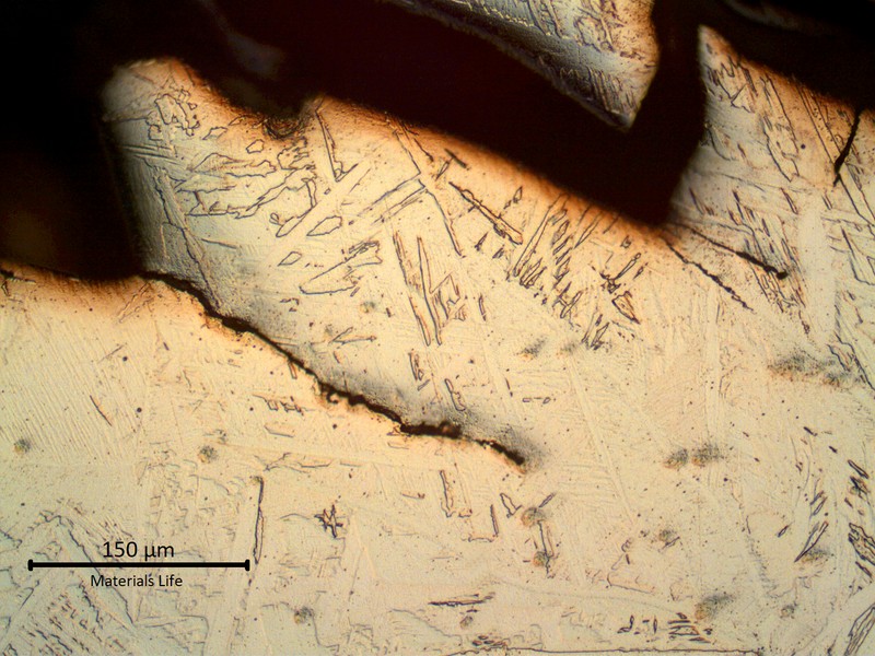 Micrographic aspect of the weld metal presenting brittle detached parts in the starting point of the fracture, in the weld metal, and several fatigue cracks propagating from the stress concentration raisers.