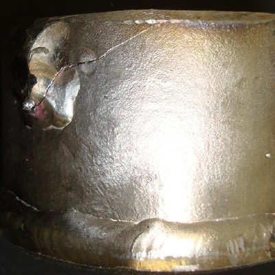 Detail of the end of the rib, with a crack in the fillet weld metal, propagating through the pipe wall.