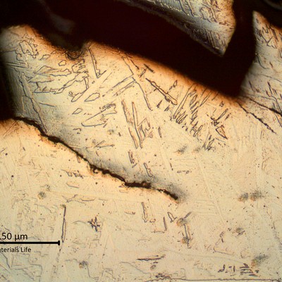 Micrographic aspect of the weld metal presenting brittle detached parts in the starting point of the fracture, in the weld metal, and several fatigue cracks propagating from the stress concentration raisers.