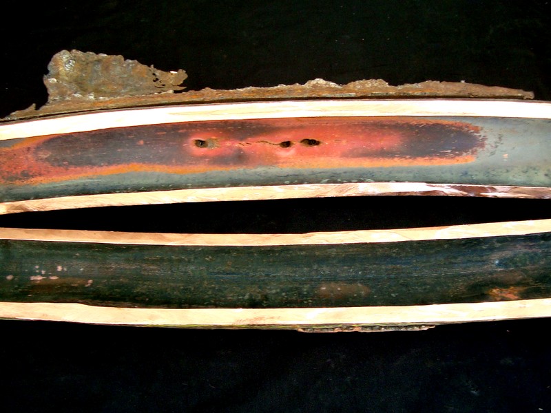 Macroscopic aspect after cutting longitudinally in two halfs, at the damaged area. The tube internal surface showed a red copper colour at the overheated region and the perforation is associated to longitudinal cracks.