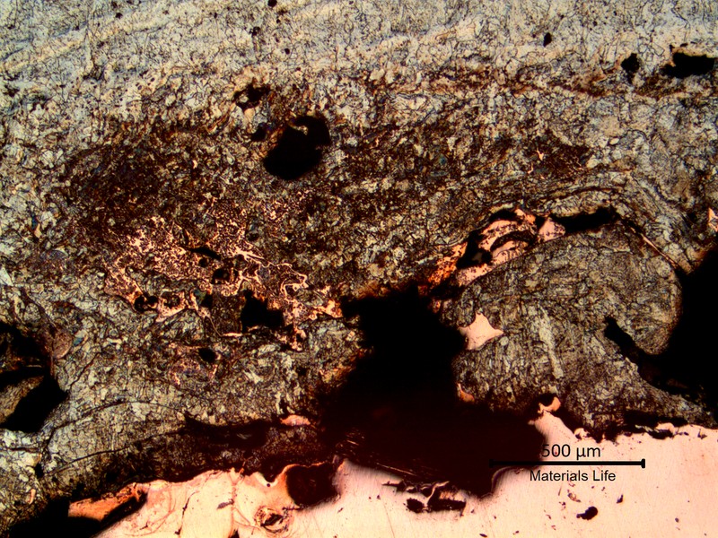 Micrography of the interface between the melted steel (top) and the copper tube (bottom), showing a mixture of melted materials.