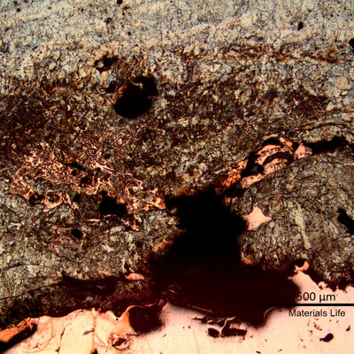 Micrography of the interface between the melted steel (top) and the copper tube (bottom), showing a mixture of melted materials.
