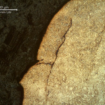 Micrographic detail of the fractured region transverse to the tooth. Secondary parallel cracks propagating in the tooth structure, tyypical of contact fatigue.