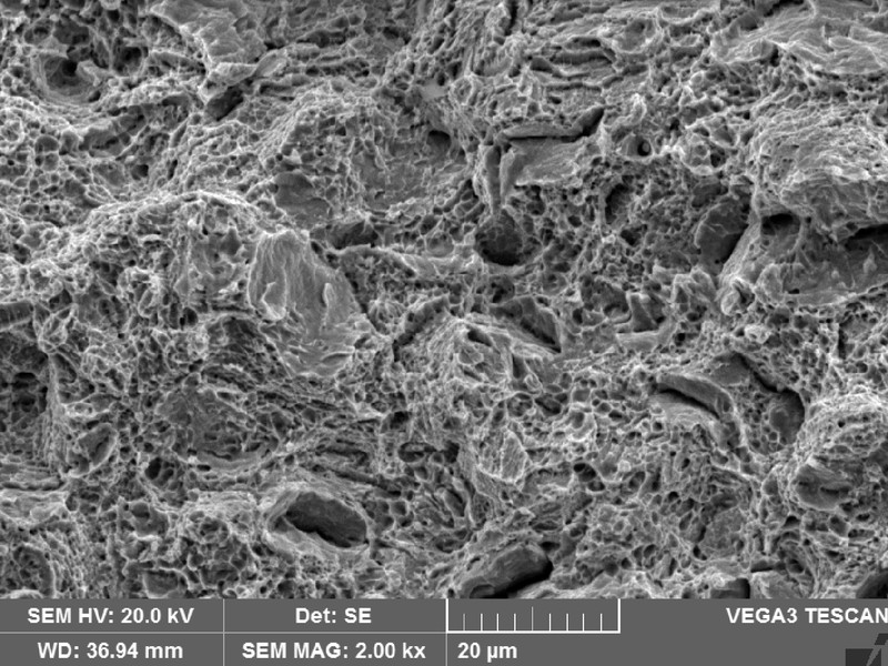 Broken tensile testpiece fractography showing predominantly dimples as the fracture micromechanism, and some integranular aspects.  It shows that in this uniaxial and without stress concentration raisers, the material presented a ductile behavior.