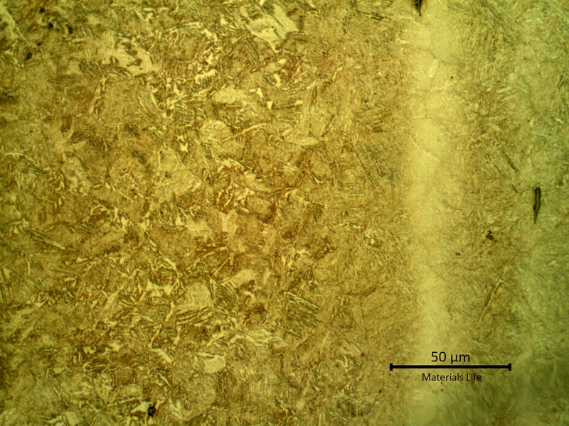 Micrography presenting a tempered martensitic microstructure, with light etch in segregated bands.