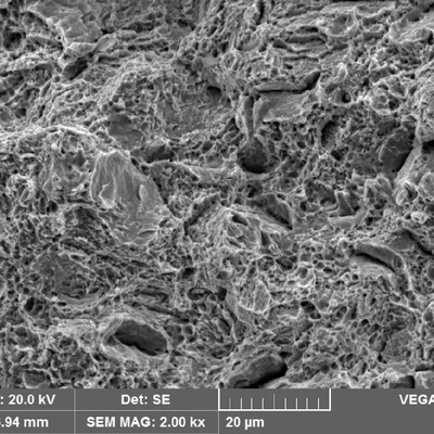 Broken tensile testpiece fractography showing predominantly dimples as the fracture micromechanism, and some integranular aspects.  It shows that in this uniaxial and without stress concentration raisers, the material presented a ductile behavior.