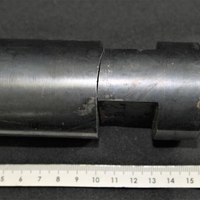 Tool fixture 5" long, nominal diameter 2", presenting a recess 1/2" deep from two sides. The rupture occurred about 2" from the end of the rod. Scale in milimeters.