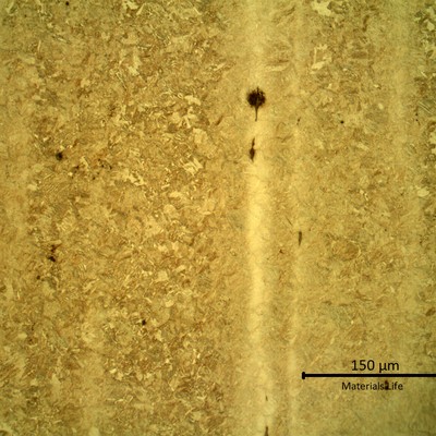Micrography presenting segregation bands (less etched) in a tempered martensitic microstructure.