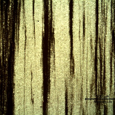 Low magnification micrography, revealing (in black) the impurities in the segregated bands.