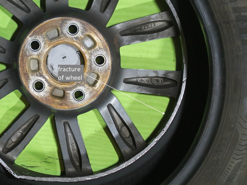 Front wheel 17 x 7J of a passenger vehicle (identified as WHEEL 1) that broke during a car accident on a road.