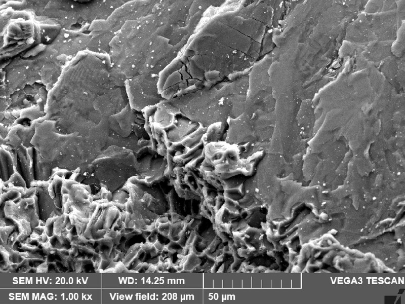 WHEEL 1 fracture detail showing small regions with smooth aspect, and brittle microcracks. But predominantly the micromechanism is by dimples.