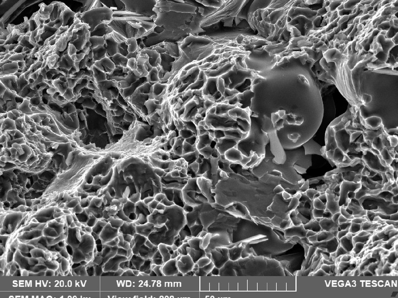 Tensile specimen fracture surface showing a small shrinkage and dimples, exactly as the WHEEL 1 fracture appearance (figure 7).